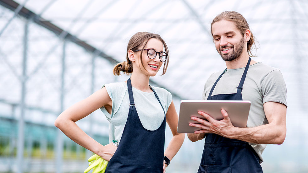 E-Learning mit OPAL. Zwei Personen schauen auf ein digitales Tablet und lernen flexibel in ihrer Arbeitsumgebung oder unterwegs.