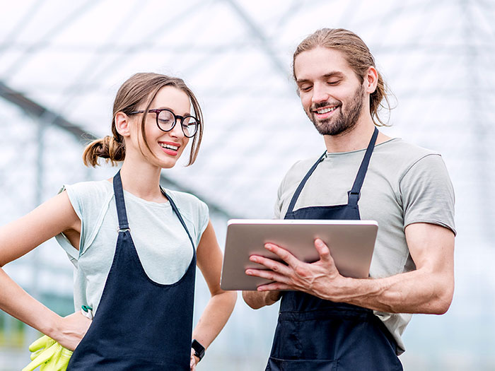 E-Learning mit OPAL. Zwei Personen schauen auf ein digitales Tablet und lernen flexibel in ihrer Arbeitsumgebung oder unterwegs.